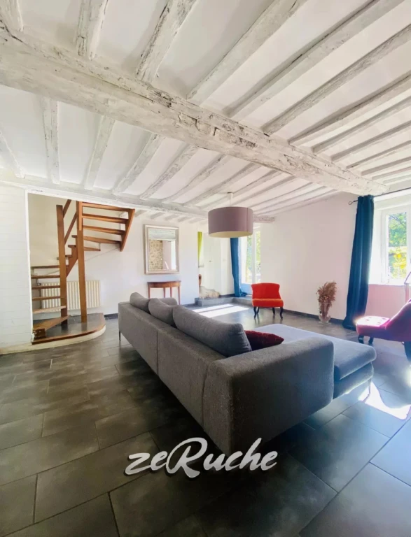 Salon lumineux avec plafond en bois apparent et mobilier moderne.