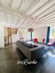 Salon lumineux avec plafond en bois apparent et mobilier moderne.