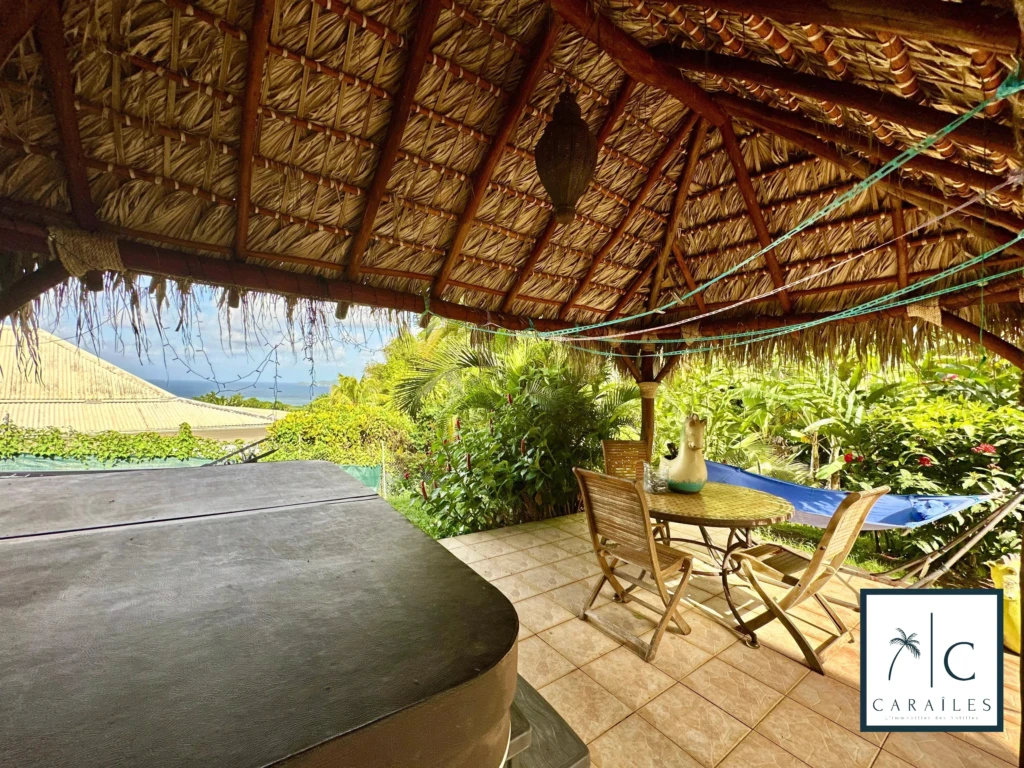 Terrasse en plein air avec vue sur la mer et mobilier confortable.