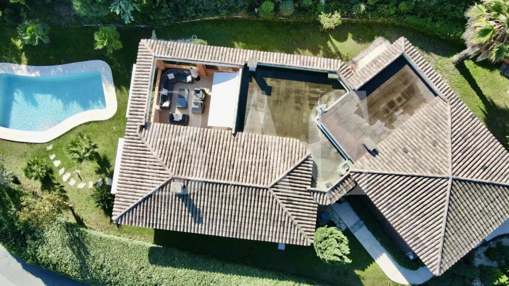 BAC Estate. Vue aérienne d'une maison avec une piscine et un patio extérieur dans un jardin verdoyant à Mandelieu-La-Napoule