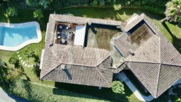 BAC Estate. Vue aérienne d'une maison avec une piscine et un patio extérieur dans un jardin verdoyant à Mandelieu-La-Napoule