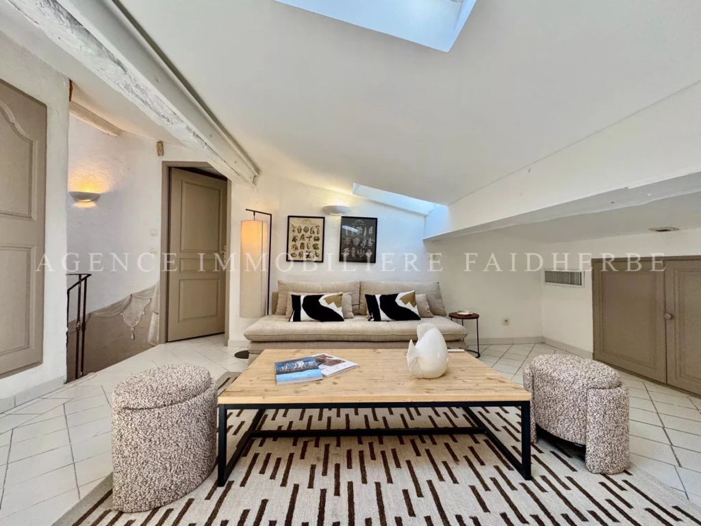 Salon lumineux avec vue sur le ciel dans un appartement moderne.