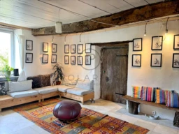 Salon lumineux avec murs ornés de photos et pièce en bois authentique.