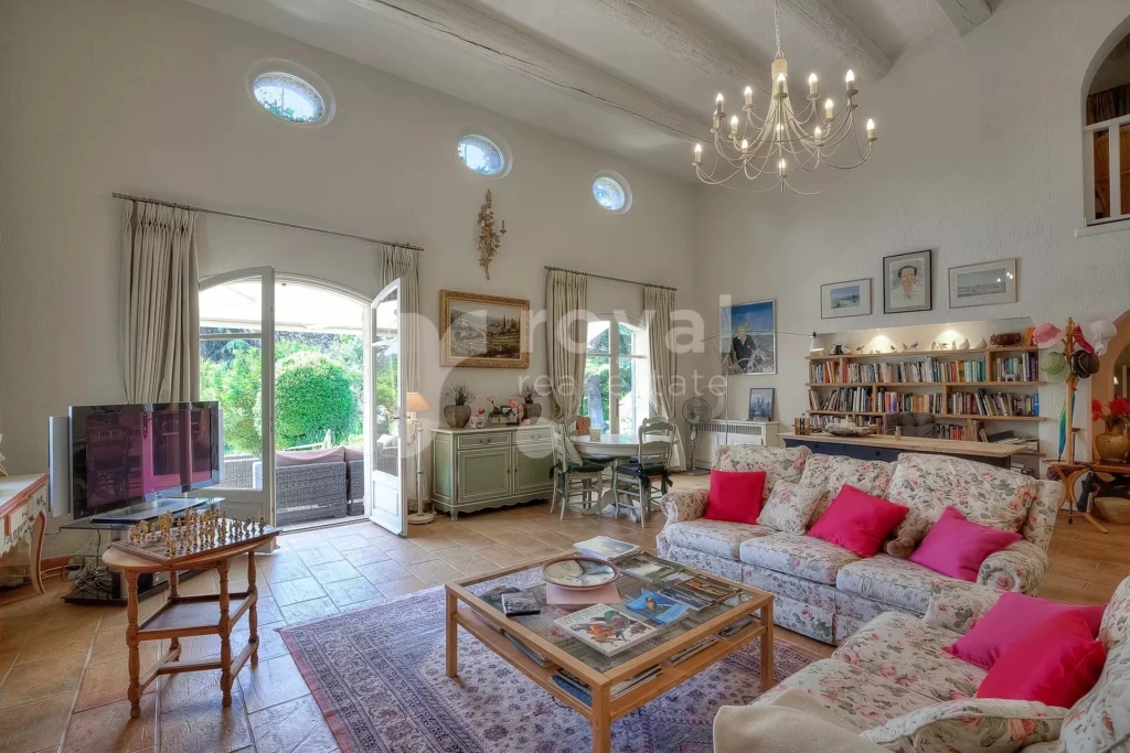 Salon chaleureux avec haut plafond, poutres apparentes, mobilier haut de gamme