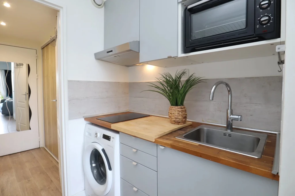 Cuisine fonctionnelle et entièrement équipée avec lave-linge dans studio à Hyères Port