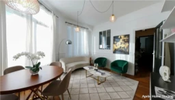 Salon lumineux avec de grandes fenêtres et un mobilier moderne.