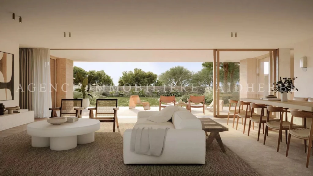 Un salon lumineux avec une vue panoramique sur le jardin et un accès à une terrasse spacieuse.