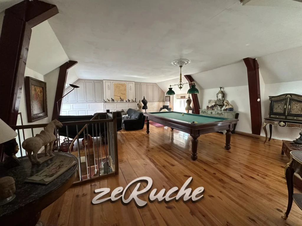 Grand salon lumineux avec parquet en bois et mobilier élégant.