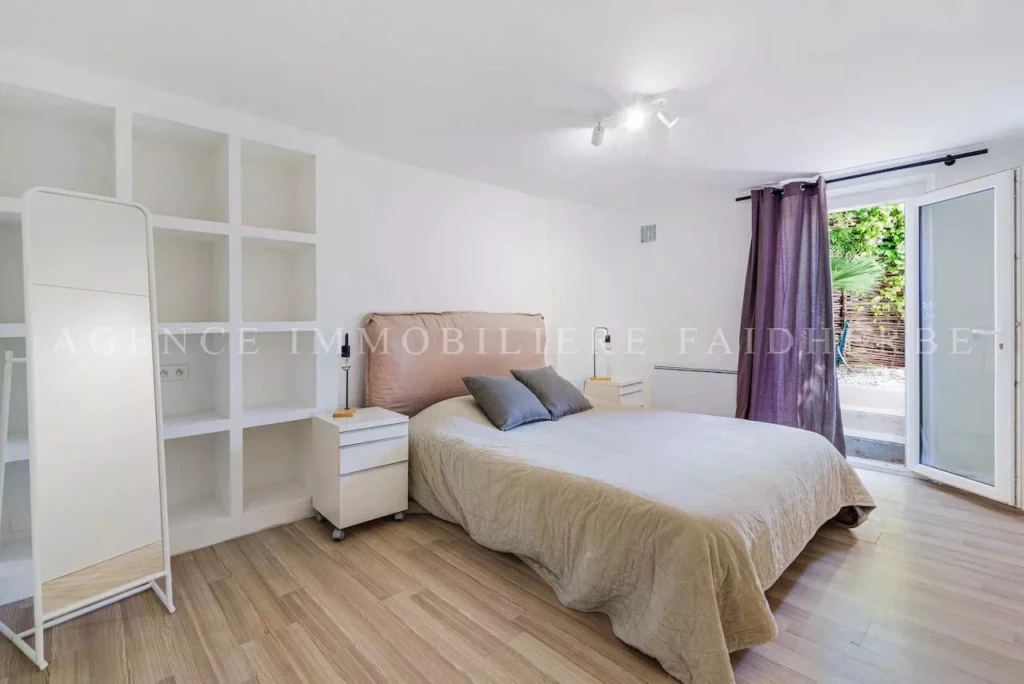 Chambre lumineuse avec accès à un patio ensoleillé et une décoration moderne.
