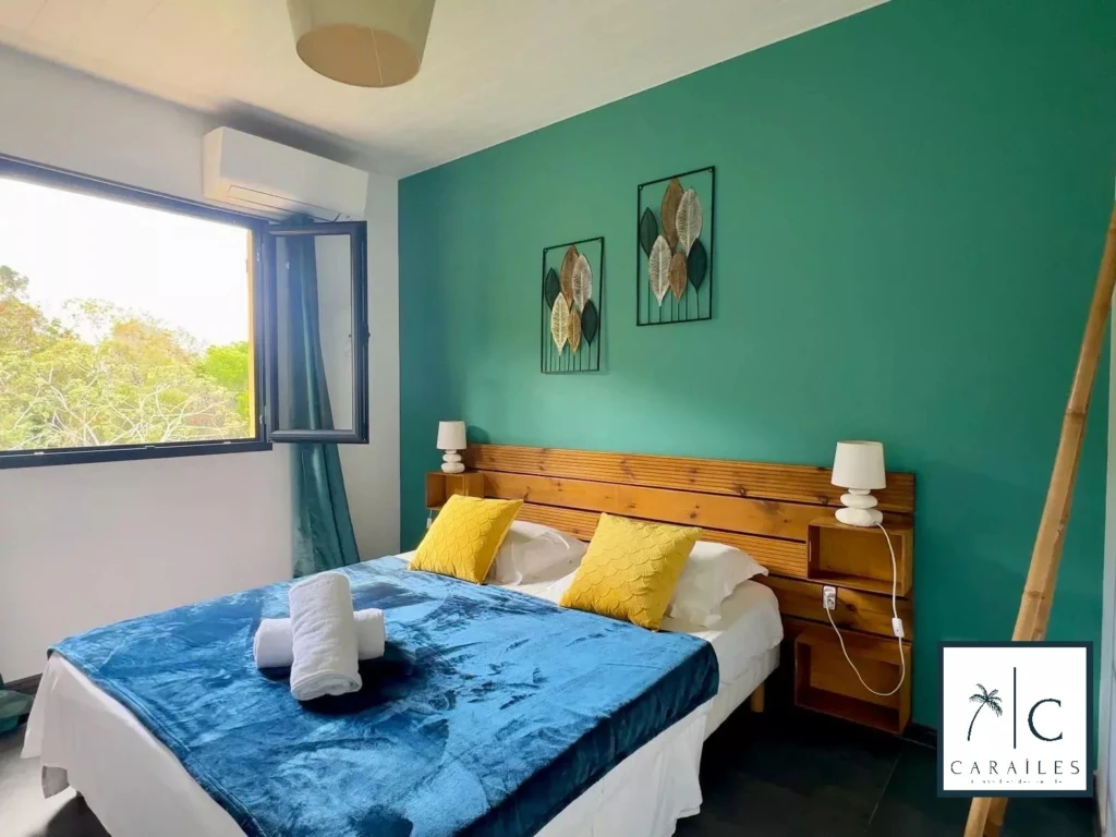 Chambre lumineuse avec un mur turquoise, idéale pour une maison moderne.