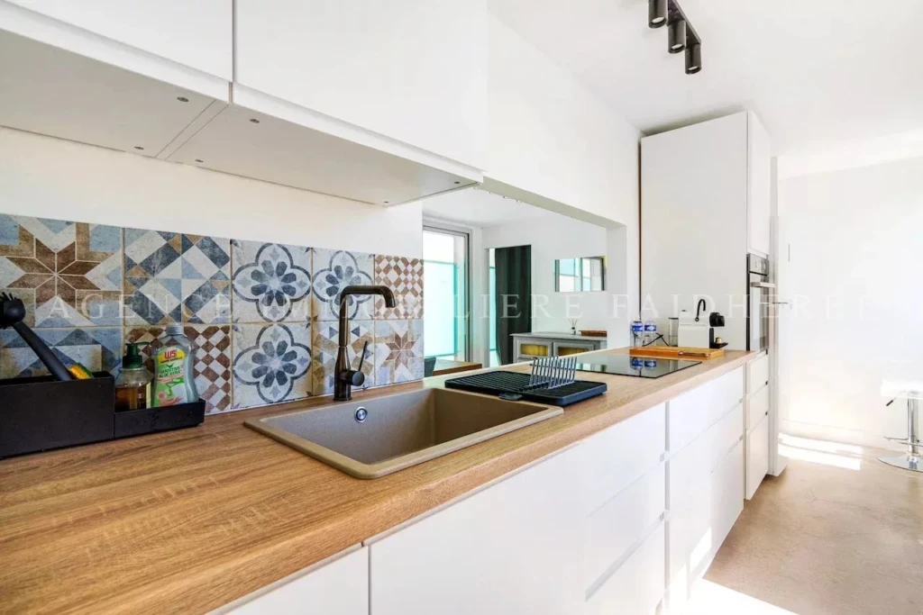 Cuisine moderne avec un plan de travail en bois et un dosseret coloré.
