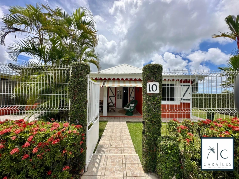 Charmante maison avec jardin tropical et accès sécurisé, idéalement située.