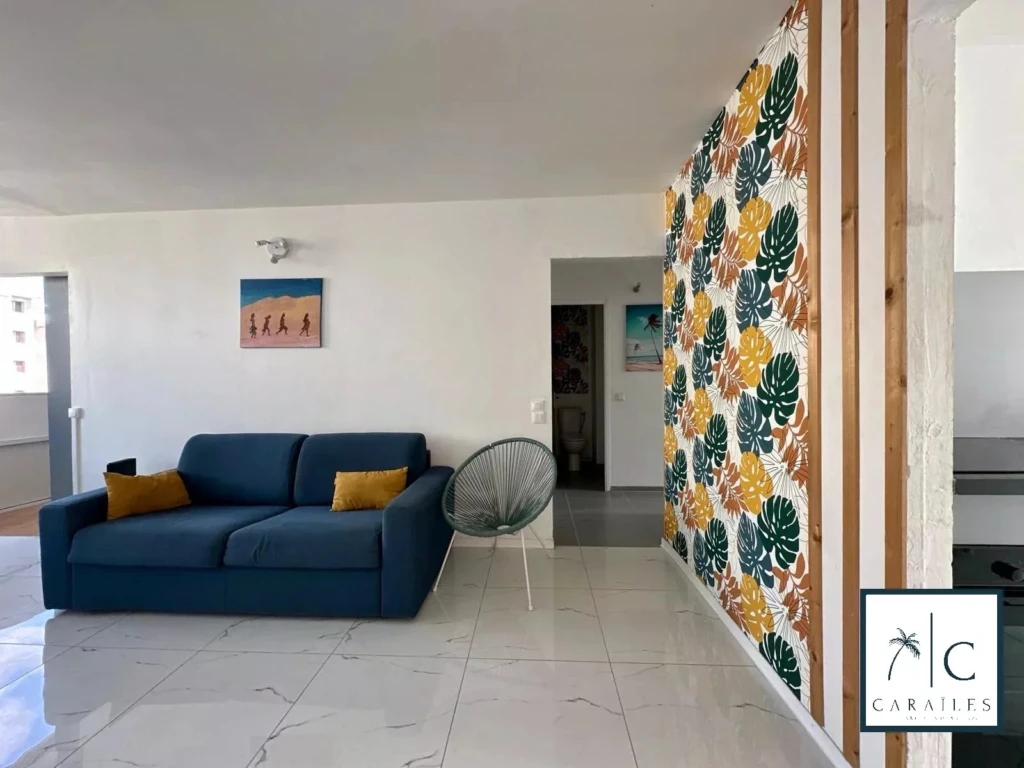 Salon lumineux avec une décoration moderne et une pièce murale colorée.