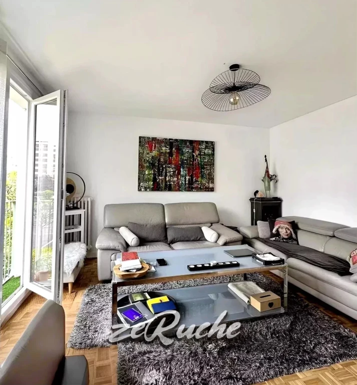 Salon lumineux avec terrasse en bord de fenêtre, mobilier contemporain et décoration moderne.