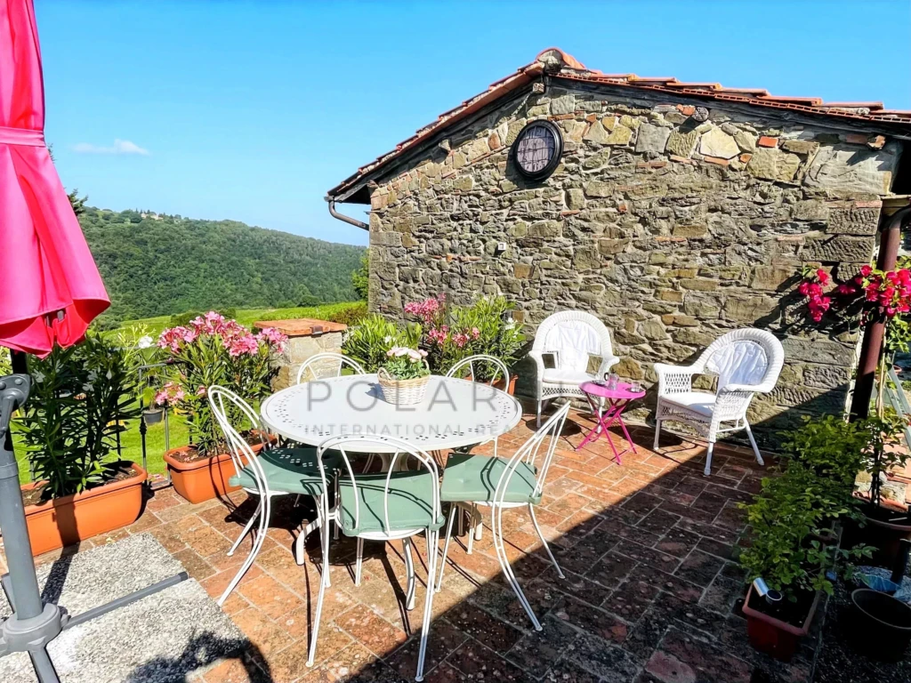 Terrasse ensoleillée avec mobilier charmant et vue sur la campagne.