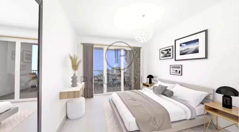 Une chambre moderne et lumineuse avec un grand lit, des draps clairs, des décorations murales et une vue sur la terrasse par des portes vitrées.