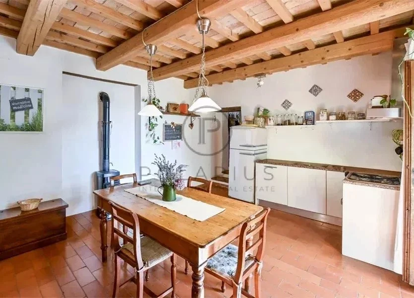 Cuisine lumineuse avec poutres en bois apparentes et espace pour un repas convivial.