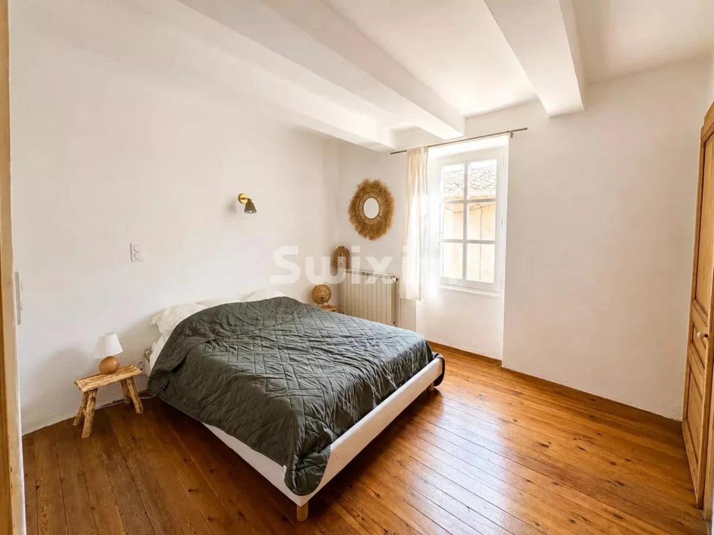 Chambre lumineuse avec parquet en bois et décoration chaleureuse.