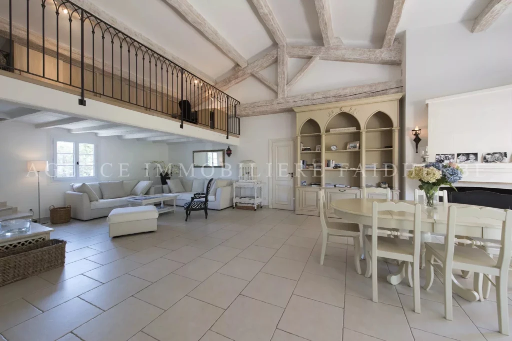 Espaces lumineux avec un plafond aux poutres apparentes et un mobilier élégant.