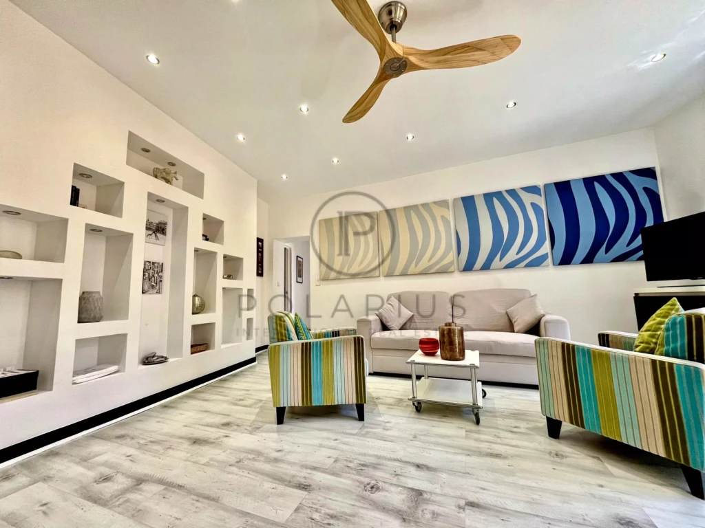 Salon moderne avec un plafond en bois et un mobilier coloré, idéal pour la détente.