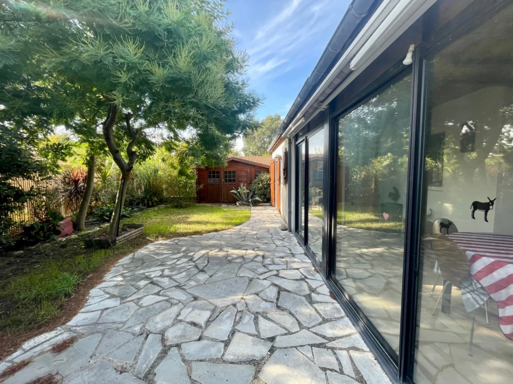 Grande baie vitrée donnant sur jardin clos arboré