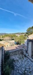 LA BASTIDE DES JOURDANS, A cozy bedroom with a metal-framed bed, wooden beams, a wardrobe with slidi