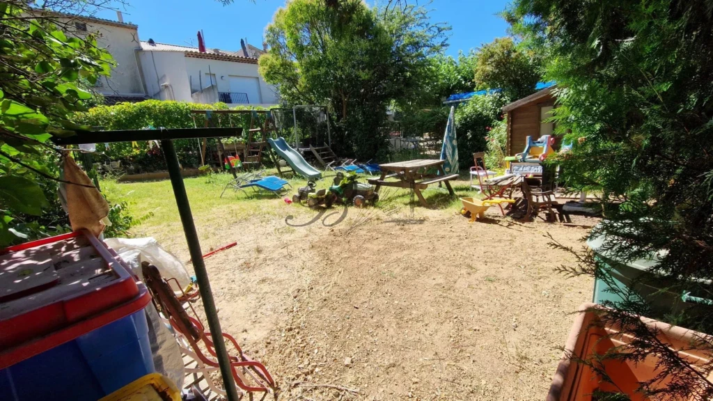 LA BASTIDE DES JOURDANS, A sunny backyard with a grassy area, some chairs, a table, and various outd