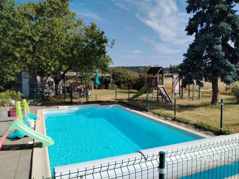 Piscine avec vue sur parc et jardin.