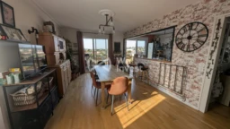 Salle à manger avec vue sur cuisine et balcon