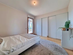 Grande chambre lumineuse avec un grand placard aménagé et un accès à une terrasse.